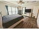A spacious main bedroom features wood floors, a ceiling fan, and light-filtering window coverings at 5304 S Wesley S Cir, Mesa, AZ 85212