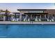 Community pool area with chaise lounges, and a modern clubhouse at 5304 S Wesley S Cir, Mesa, AZ 85212