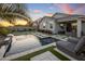 Stunning backyard featuring a modern pool, water feature, lounge chairs, and vibrant sunset at 537 E Balao Dr, Phoenix, AZ 85085