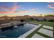 Backyard pool with mountain views, a water feature, lounge chairs, and turf at 537 E Balao Dr, Phoenix, AZ 85085