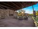 Outdoor covered patio featuring a stone fireplace, lounge seating, and manicured landscape at 537 E Balao Dr, Phoenix, AZ 85085