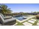 Inviting backyard pool area with stylish pavers, lush landscaping, and a tranquil waterfall feature at 537 E Balao Dr, Phoenix, AZ 85085