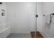 Modern walk-in shower featuring sleek white tiling, bench seating, and glass door at 537 E Balao Dr, Phoenix, AZ 85085