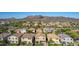 An aerial view of a residential neighborhood showcasing lush desert landscaping, and mountain views at 5423 W Yearling Rd, Phoenix, AZ 85083