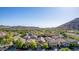 Scenic aerial view of a neighborhood with uniform homes and mountain backdrop at 5423 W Yearling Rd, Phoenix, AZ 85083