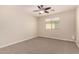 Neutral-toned bedroom with a ceiling fan, a window, and carpeted flooring at 5423 W Yearling Rd, Phoenix, AZ 85083