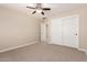 Neutral-toned bedroom with ceiling fan, carpet flooring, closet and entry door at 5423 W Yearling Rd, Phoenix, AZ 85083