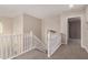 Upstairs hallway featuring white railings, carpet flooring, and an open doorway at 5423 W Yearling Rd, Phoenix, AZ 85083