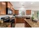 Renovated kitchen featuring granite countertops, ample storage, and modern appliances at 5423 W Yearling Rd, Phoenix, AZ 85083