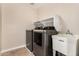 Well-lit laundry room featuring modern washer, dryer, utility sink and ample shelving at 5423 W Yearling Rd, Phoenix, AZ 85083