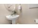 Elegant powder room featuring a pedestal sink, round mirror, and fresh white towels at 5423 W Yearling Rd, Phoenix, AZ 85083
