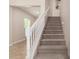 Carpeted staircase with white railing leads to the upper level, complemented by neutral walls at 5423 W Yearling Rd, Phoenix, AZ 85083