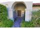 View of front door through gated archway featuring mature landscaping and a brick walkway at 5718 N 72Nd Pl, Scottsdale, AZ 85250