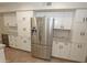 Bright kitchen with stainless steel refrigerator, wine cooler, white cabinets and granite countertops at 5718 N 72Nd Pl, Scottsdale, AZ 85250