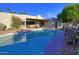 Stunning backyard oasis with a sparkling pool, covered patio, lounge area, and colorful desert landscaping at 5718 N 72Nd Pl, Scottsdale, AZ 85250