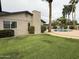 Well-manicured backyard with green lawn, private pool, mature landscaping, and patio at 5751 E Ludlow Dr, Scottsdale, AZ 85254