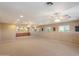 Large basement featuring neutral carpet, recessed lighting, multiple windows, and a built-in bar at 5751 E Ludlow Dr, Scottsdale, AZ 85254