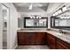 Full bathroom featuring large decorative mirrors, granite countertops, and warm-toned wood cabinetry at 5751 E Ludlow Dr, Scottsdale, AZ 85254