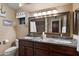 Bathroom vanity featuring double sinks, granite countertops, modern fixtures, and decorative accents at 5751 E Ludlow Dr, Scottsdale, AZ 85254