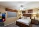 Cozy bedroom with a rustic wooden bed frame, ceiling fan, and Western-themed decor at 5751 E Ludlow Dr, Scottsdale, AZ 85254