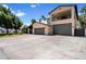 Expansive driveway leading to a home with an upper floor balcony and attached three-car garage at 5751 E Ludlow Dr, Scottsdale, AZ 85254