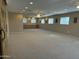 Expansive living room with multiple windows, ceiling fans, and built in cabinets with a small refrigerator at 5751 E Ludlow Dr, Scottsdale, AZ 85254