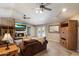 Warm living room with a cozy fireplace, plush sofas, ceiling fans, and access to the outdoors at 5751 E Ludlow Dr, Scottsdale, AZ 85254