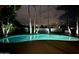 Backyard oasis featuring a private pool, palm trees, and charming string lights at night at 5751 E Ludlow Dr, Scottsdale, AZ 85254