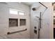 Shower featuring rainfall showerhead, sleek fixtures, and white marble tile with decorative inset at 5751 E Ludlow Dr, Scottsdale, AZ 85254
