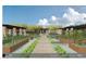Landscaped organic garden showing a stone pathway with raised planting beds and shaded seating areas at 6228 N Cattle Track Rd, Scottsdale, AZ 85250