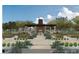 Outdoor dining with fireplace and seating amidst an organic garden with trees and custom plant boxes at 6228 N Cattle Track Rd, Scottsdale, AZ 85250