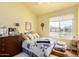 Bedroom with a bed, dresser, and window, creating a bright and welcoming atmosphere at 7302 W Meadowbrook Ave, Phoenix, AZ 85033