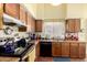 A well-lit kitchen with wood cabinets, stainless steel appliances, and a double sink at 7302 W Meadowbrook Ave, Phoenix, AZ 85033