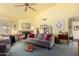 Bright living room with a gray sofa, ceiling fan, and red brick fireplace at 7302 W Meadowbrook Ave, Phoenix, AZ 85033