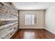Bedroom featuring a reclaimed wood accent wall, hardwood floors, and bright, natural light at 750 E Northern Ave # 1089, Phoenix, AZ 85020