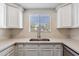Updated kitchen features sleek countertops, stainless steel sink, and ample white cabinet storage at 750 E Northern Ave # 1089, Phoenix, AZ 85020