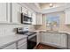 Well-lit kitchen showcasing stainless steel appliances, white countertops, and bright white cabinets at 750 E Northern Ave # 1089, Phoenix, AZ 85020