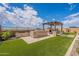 Spacious artificial turf backyard with a cozy patio and outdoor kitchen area, perfect for hosting gatherings at 8021 E Jasmine St, Mesa, AZ 85207