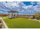 Lush backyard featuring artificial turf, a cozy patio area, and an outdoor cooking area for entertaining guests at 8021 E Jasmine St, Mesa, AZ 85207