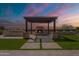 Inviting backyard showcasing a pergola, outdoor fireplace, built-in grill, and manicured artificial turf, perfect for entertaining at 8021 E Jasmine St, Mesa, AZ 85207