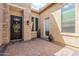 Inviting entryway featuring a decorative front door, brick-paved patio, and neutral stucco walls at 8021 E Jasmine St, Mesa, AZ 85207