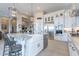 Modern kitchen featuring an island with a white farmhouse sink, stainless steel appliances, and barstool seating at 8021 E Jasmine St, Mesa, AZ 85207