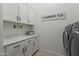 Bright laundry room with upper and lower cabinets, countertops, stylish decor, and modern appliances at 8021 E Jasmine St, Mesa, AZ 85207