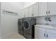 Well-equipped laundry room featuring modern washer/dryer units, ample storage cabinets, sink and stylish countertops at 8021 E Jasmine St, Mesa, AZ 85207