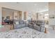 The comfortable living room features a large sectional sofa, an accent rug, and an open layout to the dining and kitchen areas at 8021 E Jasmine St, Mesa, AZ 85207