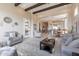 Spacious living room with wood beams, modern furniture, and an open floor plan into the kitchen at 8021 E Jasmine St, Mesa, AZ 85207
