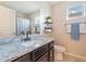 This bathroom has granite counters, dark cabinets, a toilet, a plant, and a window at 8043 W Albeniz Pl, Phoenix, AZ 85043