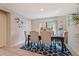 Cozy dining area featuring a dark wood table, upholstered chairs, and a decorative blue rug at 8043 W Albeniz Pl, Phoenix, AZ 85043