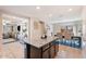 Well-equipped kitchen featuring dark wood cabinets, granite countertops, an island, and open to dining at 8043 W Albeniz Pl, Phoenix, AZ 85043