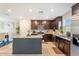 Well-equipped kitchen featuring dark wood cabinets, granite countertops, and a functional center island at 8043 W Albeniz Pl, Phoenix, AZ 85043